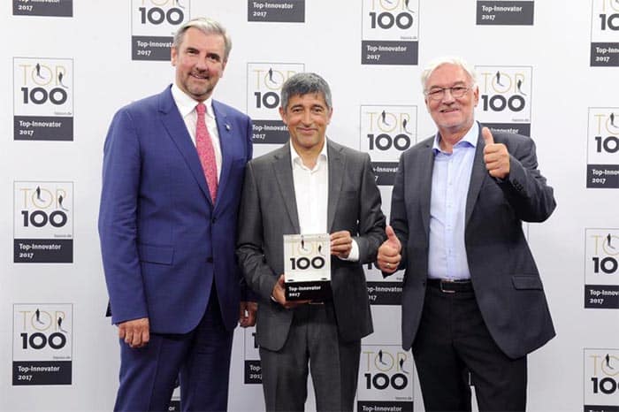 El Dr. Gereon Schäfer, Presidente y Horst Pachowiak,Jefe de Innovación en Surteco Decor, aceptaron el sello TOP 100 del periodista científico Ranga Yogeshwar.